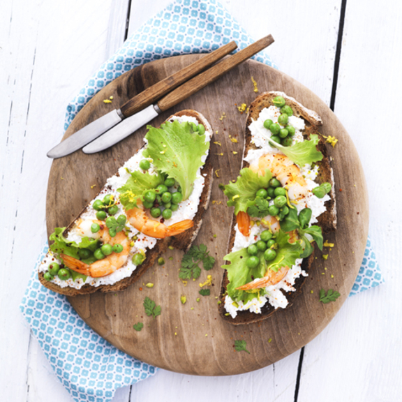 Goat cheese on toast with peas and shrimp