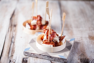 Bites of goat cheese camembert with bacon and honey